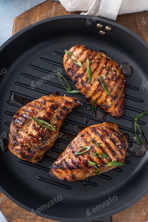Preview: Grilled teriyaki chicken breast on a grill pan with green onions