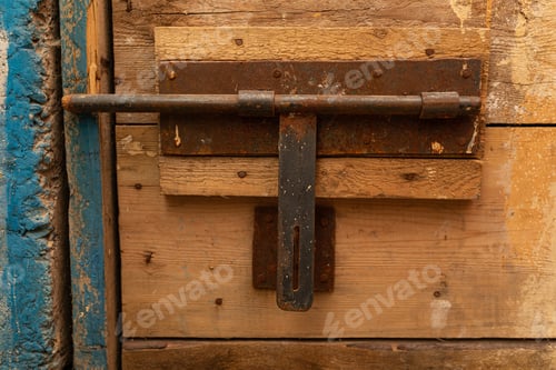 Preview: An old rusty latch of a rough wooden door