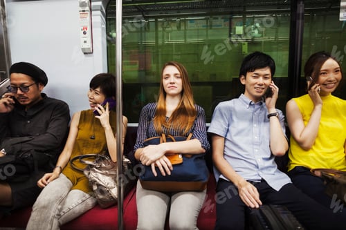 Preview: Five people sitting sidy by side on a subway train, Tokyo commuters.