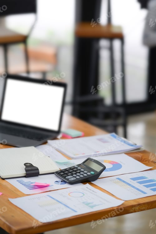 Preview: Laptop computer, calculator and documents on wooden table.