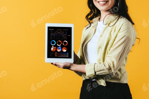 Preview: cropped view of girl showing digital tablet with infographic, isolated on yellow