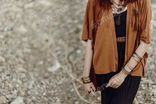 Preview: Hipster girl in gypsy look young traveler posing near river beach in mountains