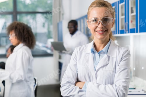Preview: Portrait Of Smiling Woman In White Coat And Protective Eyeglasses In Modern Laboratory, Female