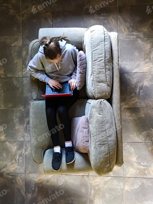 Preview: Teenage Student Relaxing on Couch with Laptop
