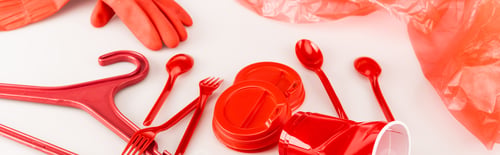 Preview: red plastic objects scattered on white background, panoramic shot