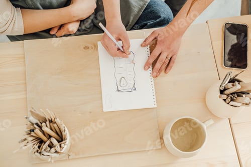 Preview: A woman draws a sketch of a ceramic product.