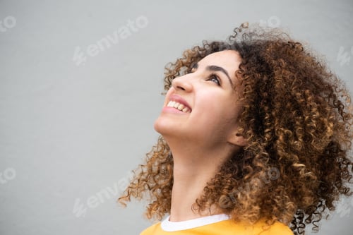 Preview: Close up side of young woman smiling and looking up