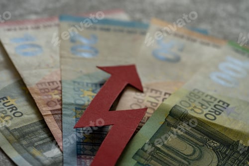 Preview: Red upward arrow lying on euro bills - the concept of raising European money rates