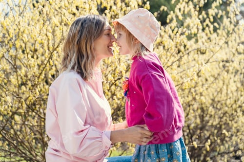 Preview: Mother and daughter happy together in blooming trees garden at spring. Happy mother's day!