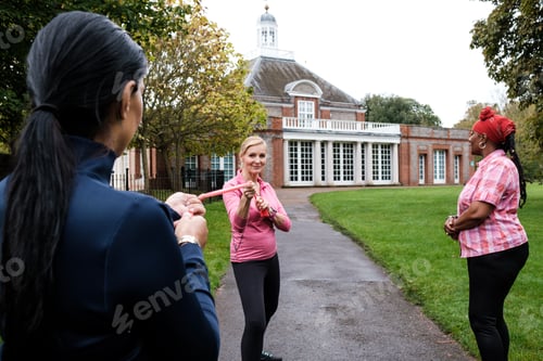 Preview: Group of mature women using resistance band in a park.