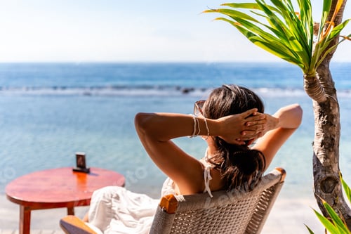 Preview: Young woman traveler relaxing and enjoying the beach view while traveling for summer vacation