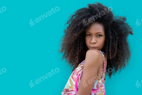 Preview: beautiful young woman posing on an aquamarine blue background