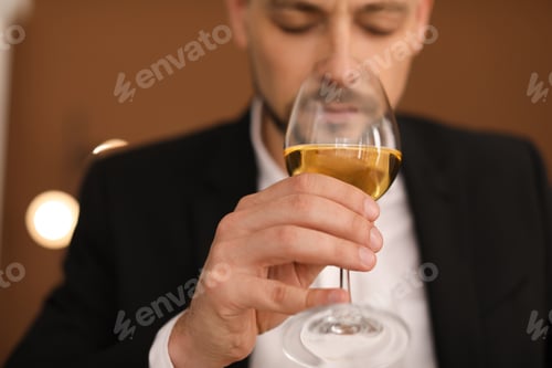 Preview: Young man with glass of wine indoors