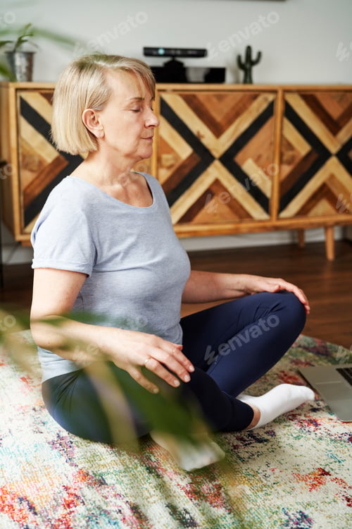 Preview: Vertical image of senior woman meditating
