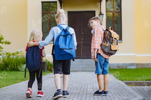Preview: children walking to school with backpacks on sunny day. Begining of academic year. Boys by school
