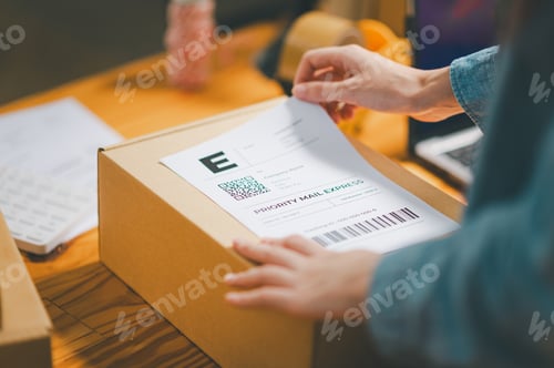 Preview: startup young female small business owners attaching shipping labels to cardboard boxes
