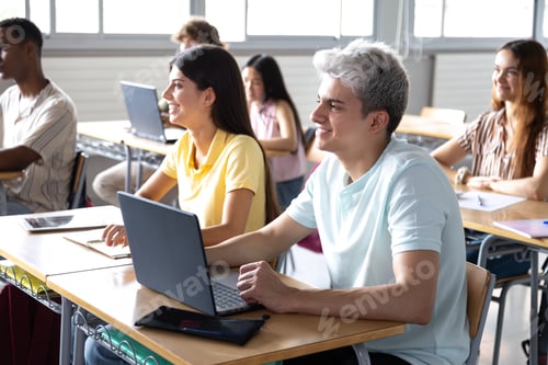 Preview: University students using laptops following a lecture in classroom