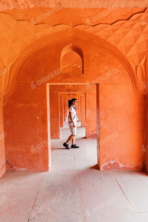 Preview: Vibrant travel guy in orange hallway in India