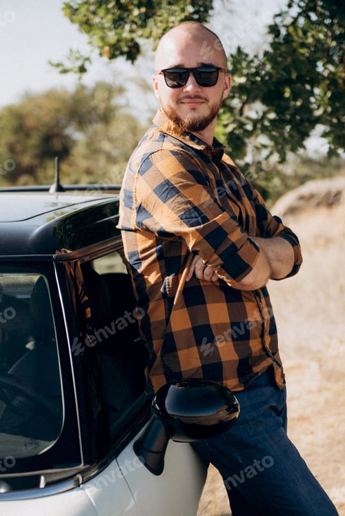 Preview: Guy in a plaid shirt next to a white car