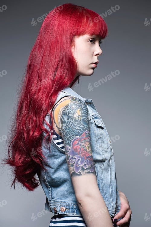 Preview: Young woman with long red hair and tattoos, profile