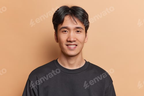 Preview: Portrait of handsome young Vietnamese man smiles gladfully shows white teeth has joyful expression