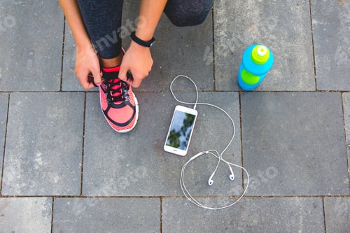 Preview: The woman lace up shoes near the phone