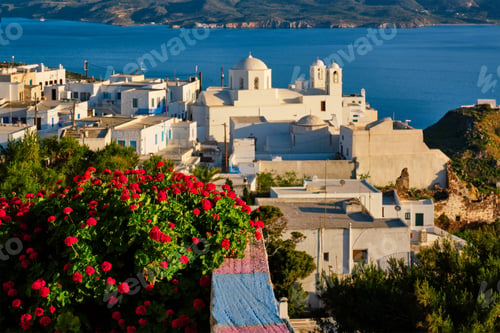 Preview: Picturesque scenic view of Greek town Plaka on Milos island over red geranium flowers