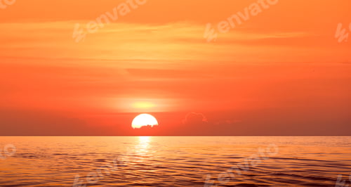 Preview: Sunrise sky over sea with the sun behind cloud and reflection on water surface in the morning