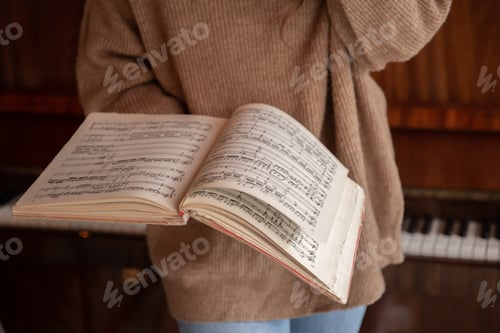 Preview: Close-up of musical notes in female hands.