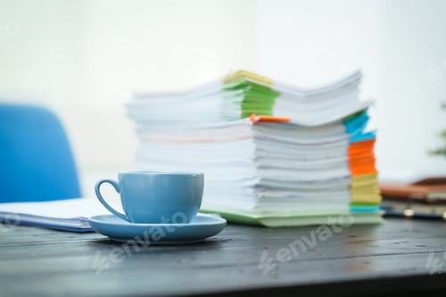 Preview: An empty office desk is cluttered with numerous documents scattered coffee cups.The scene reflects