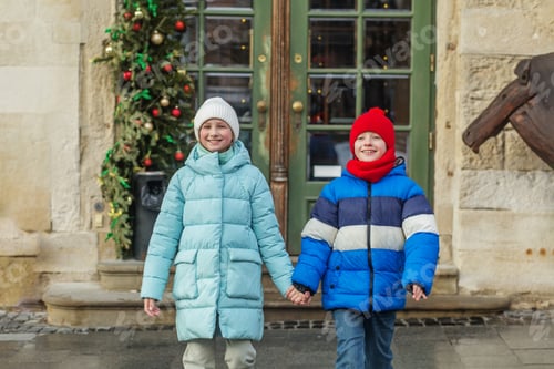 Preview: Happy children walking hand in hand at Christmas