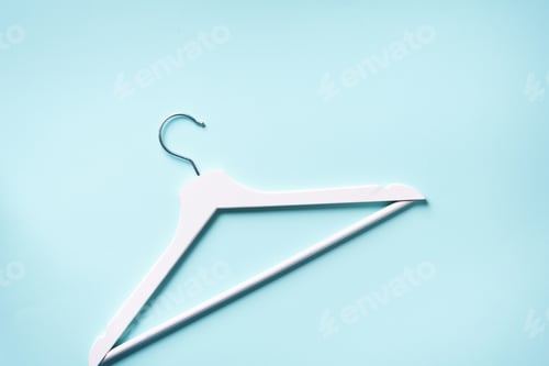 Preview: White clothes hangers on blue background with copy space. Flat lay. Top view. Minimalism style