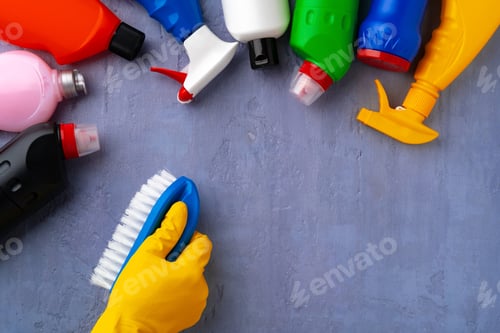 Preview: Cleaning supplies with hands in rubber gloves on gray background