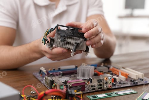 Preview: Male technician repairing computer fan at table, closeup