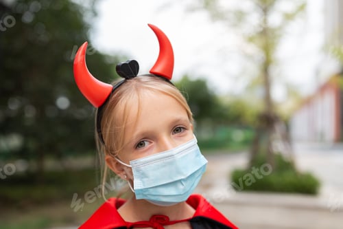 Preview: Happy kid in evil costume celebrating Halloween 2020 during coronavirus covid-19 pandemic