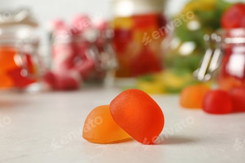 Preview: Tasty orange jelly candies on light table, closeup. Space for text