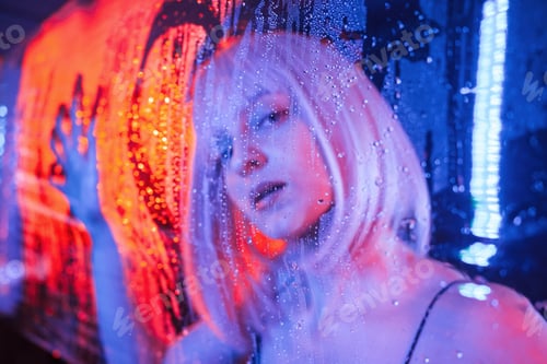 Preview: Love heart shape on surface. Stylish woman with white hair is behind wet transparent plastic sheet