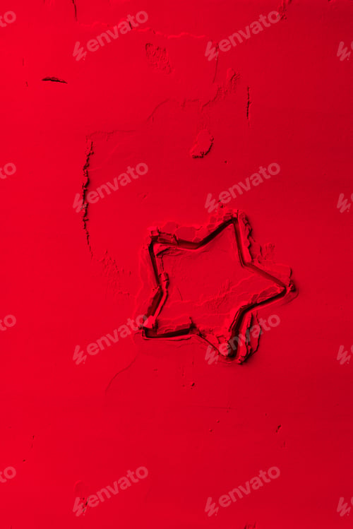 Preview: elevated view of shape of cookie cutter in shape of star on red powder