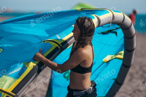 Preview: Woman preparing her kite for kitesurfing