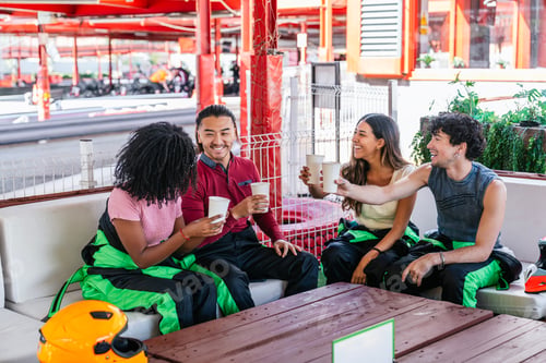 Preview: Friends relaxing at go kart circuit cheering drinks