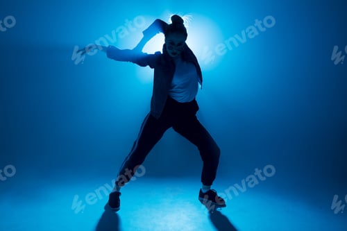 Preview: Young hip-hop female dancer performing solo on the stage in blue neon lights