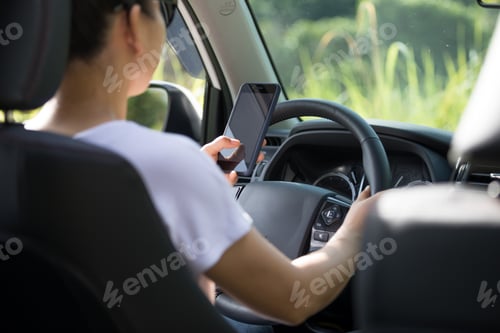 Preview: DrivingWoman driver using smartphone while driving a off road car in the nature