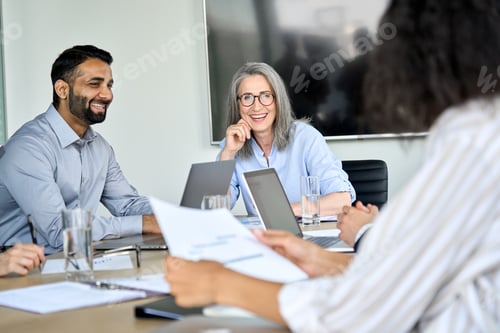 Preview: Happy diverse corporate team working together in meeting room office.