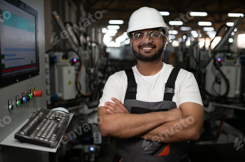 Preview: Young Indian male engineer wearing safety workwear standing in the factory