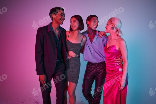 Preview: happy multiethnic men in festive attire and women in dresses celebrating Christmas on purple pink