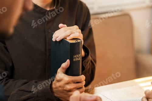 Preview: Man Holding Bible Discussing Faith with Friend