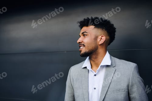 Preview: Portrait of young man student standing outdoors in city against black background