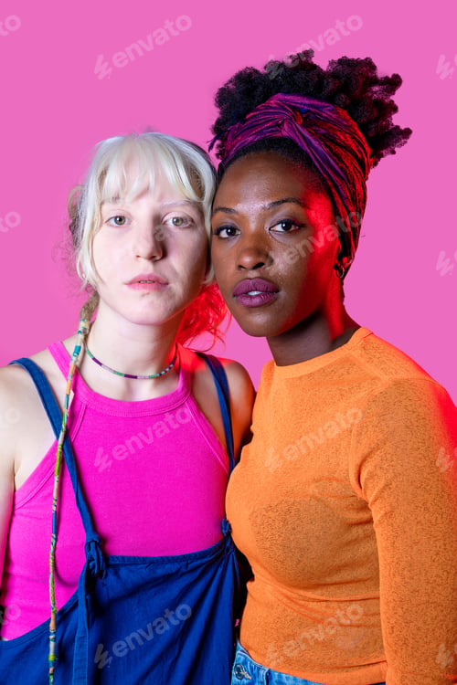 Preview: Portrait of two diverse women friends posing isolated background standing for equality
