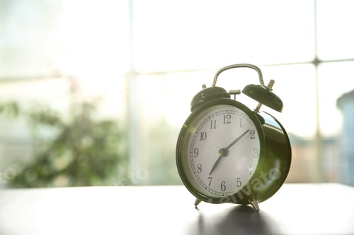 Preview: Black alarm clock on table in morning. Space for text