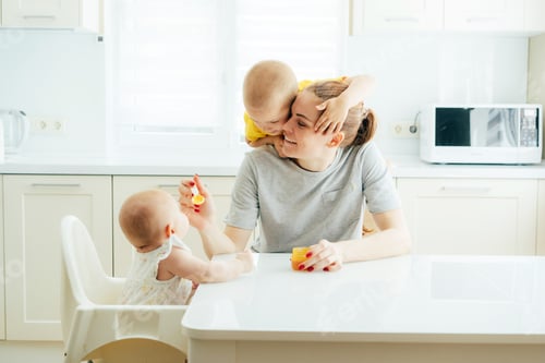 Preview: Mom feeds the baby with false vegetable puree, the older child hugs mom.